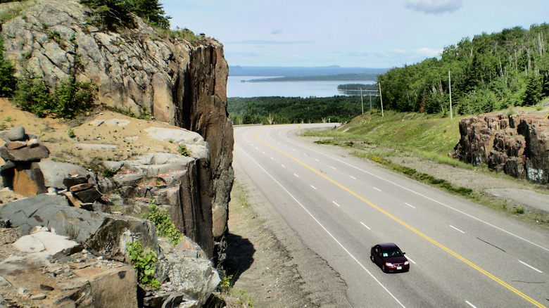 car on highway, rocky cliffs lake superior