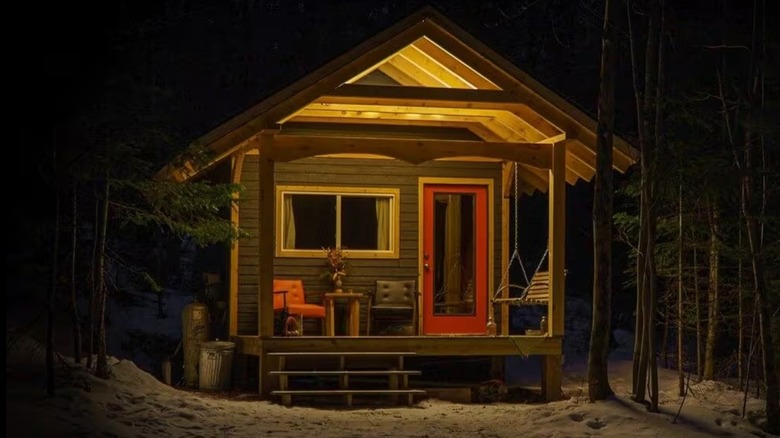 Small forest cabin illuminated at night
