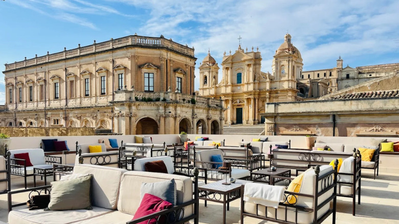 The rooftop bar of Gagliardi Hotel in Noto, Sicily, overlooking a church and other ornate buildings