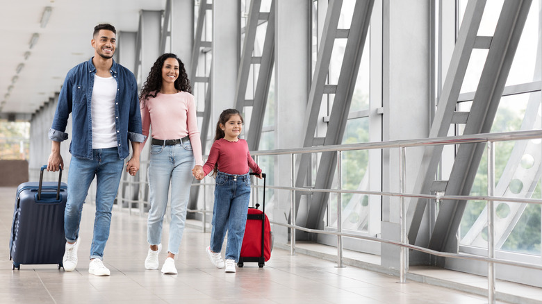 Family walking through airport with baggage