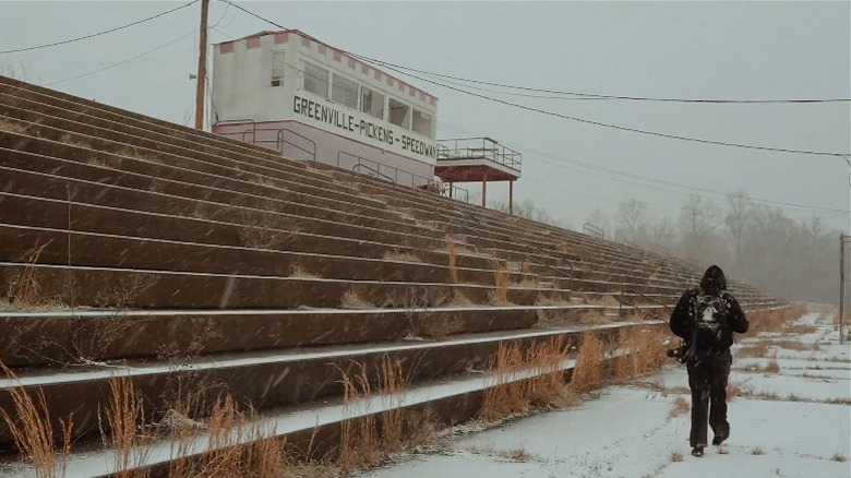 Man walks in abandoned Greenville-Pickens Speedway on a snowy day