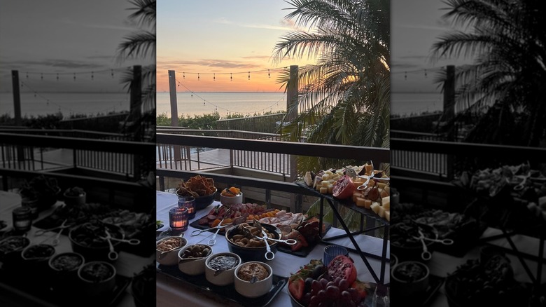 A buffet spread in front of an ocean sunset over Oystercatchers restaurant at the Grand Hyatt