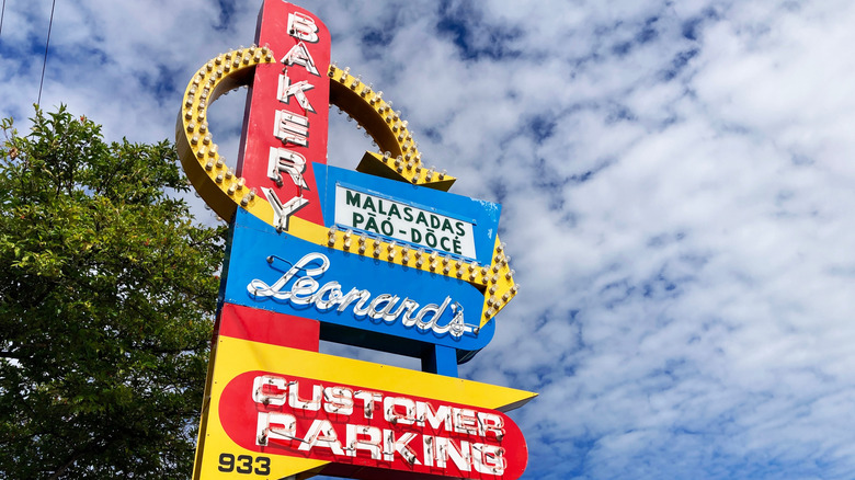 Leonard's Bakery sign with trees and a blue sky in the background