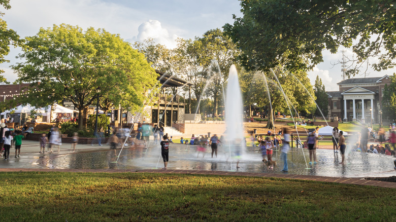 Children playing around a water fountain in a park in Duluth near the City Hall.