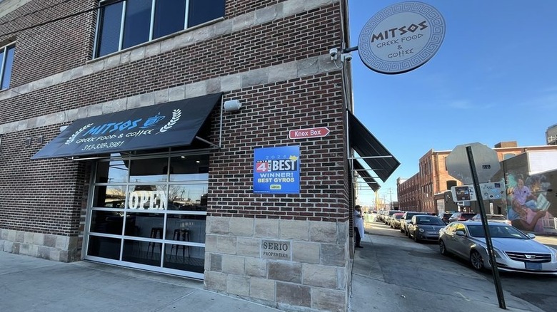 The exterior of Mitsos, showing the awning and a sign on a brick building