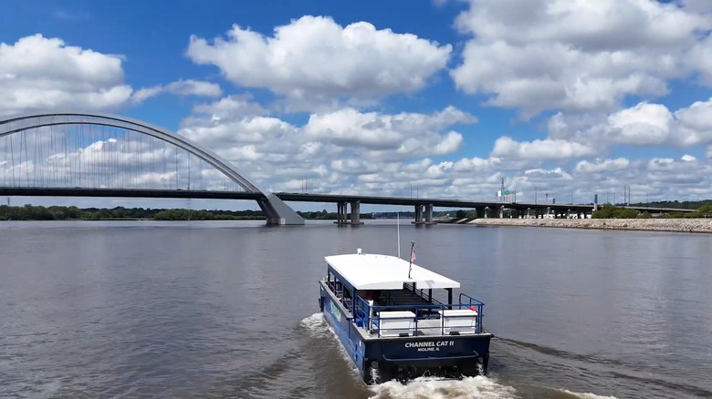 A view of the Channel Cat Water Taxi on the Mississippi with an arched bridge in the background