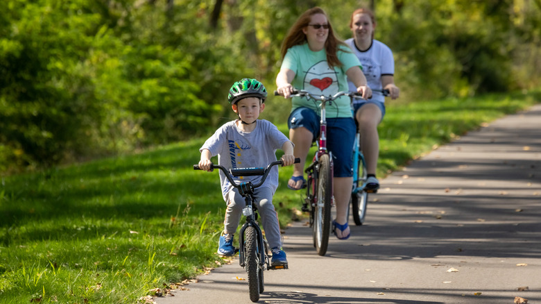 A family riding bikes down a trail