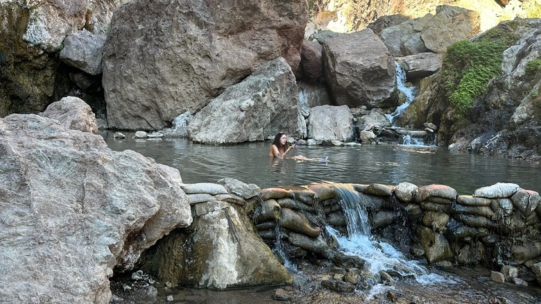 A woman soaking in Gold Strike Hot Springs on the Black Canyon Water Trail