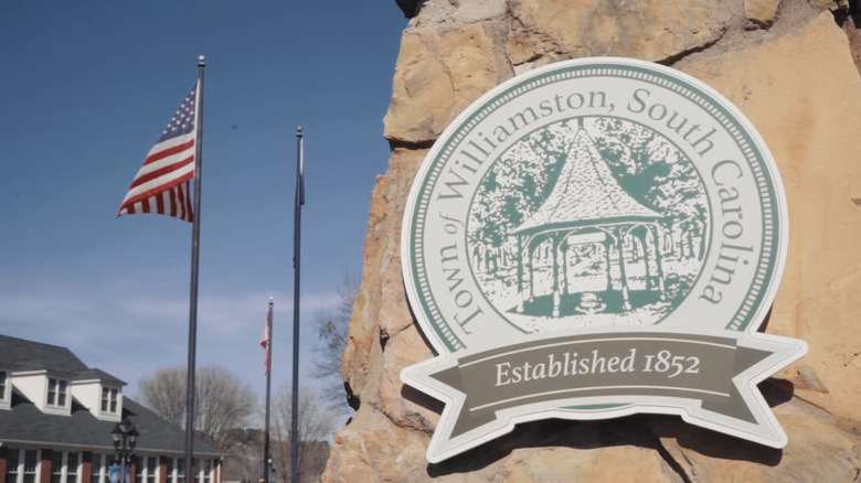 Sign that reads "Town of Williamston, South Carolina, Established in 1852," with an American flag waving
