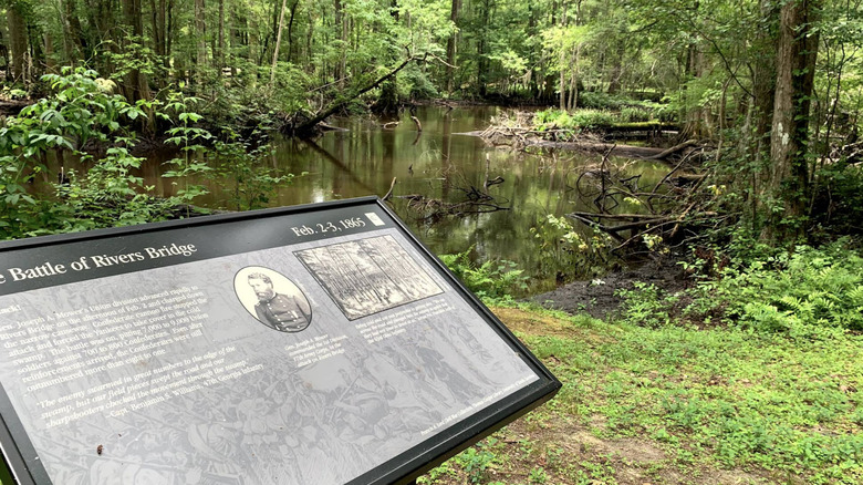 An information panel along a trail within Battle of Rivers Bridge State Historic Site.
