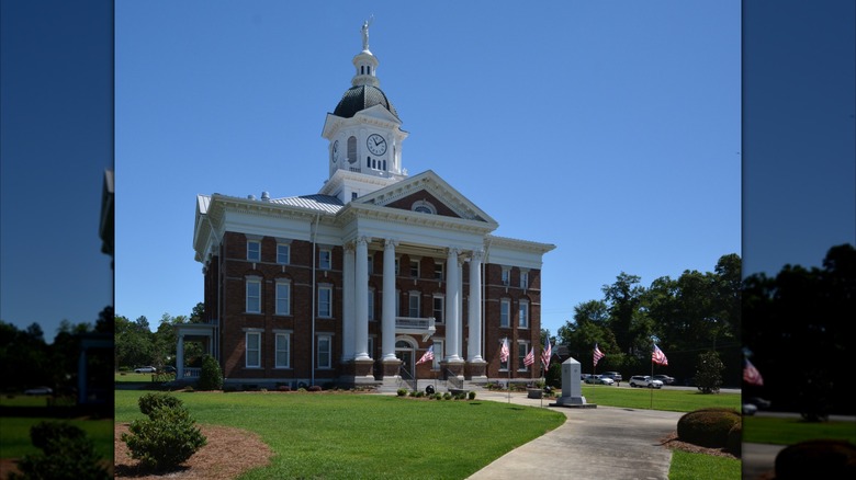 The Jenkins County Courthouse building, a three-story brick building with tall white pillars, in Millen, Georgia
