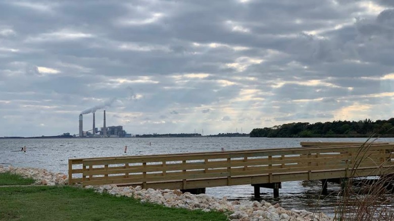 A wooden pier at Lake Fayette Oak Thicket Park with the power plant in the background