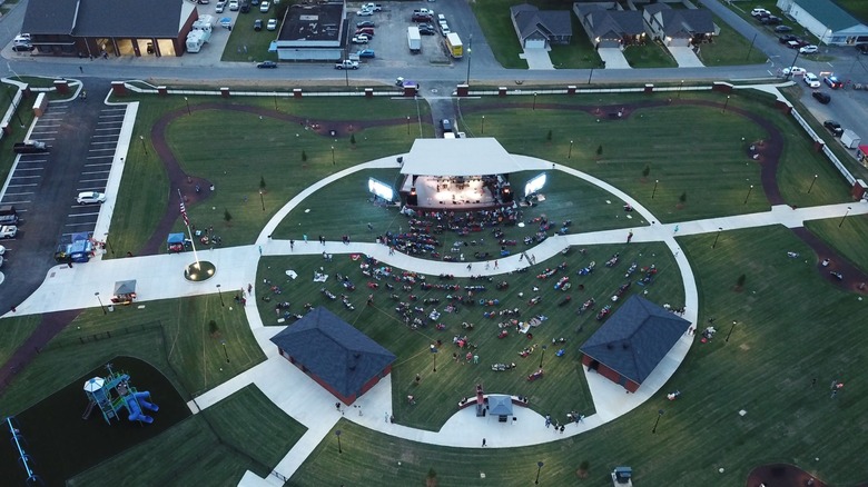 Aerial view of Old Mill Park during an event, with people crowded around an outdoor stage