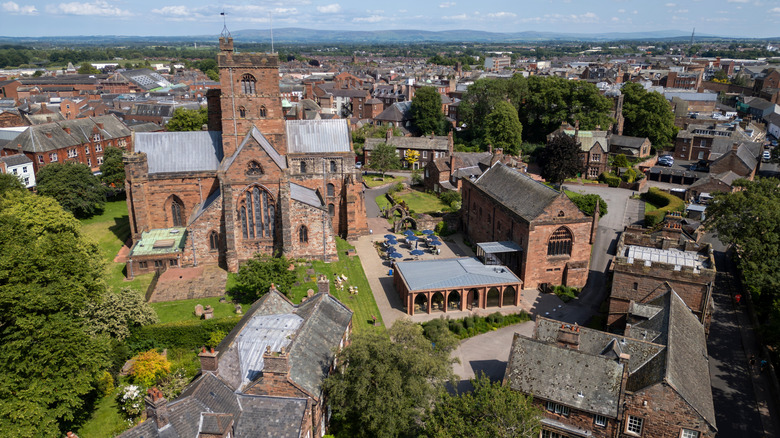 Red brick cathedral and historic district surrounded by greenery and set against cityscape