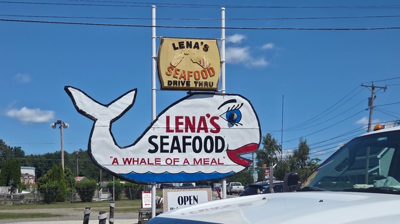 A sign for Lena's Seafood in the shape of a whale, with the text "a whale of a meal"
