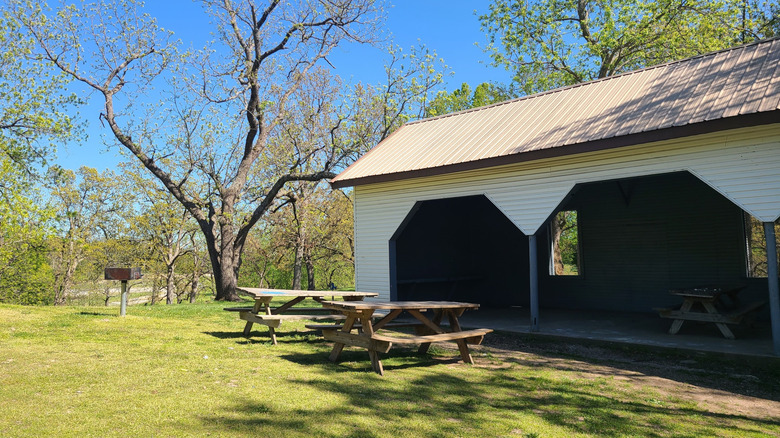 Picnic shelter with tables surrounded by trees at Monett City Park in Monett, Missouri