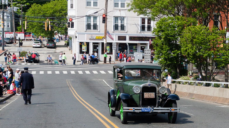 Vintage green car driving through downtown Shelton, Connecticut during a parade