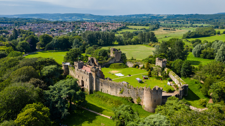 Aerial view of Caldicot Castle and Country Park with surrounding trees, fields, and houses in the town of Caldicot