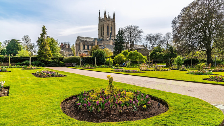 A path flanked by a lawn with flowerbeds in front of St. Edmundsbury Cathedral, Bury St. Edmunds, Suffolk