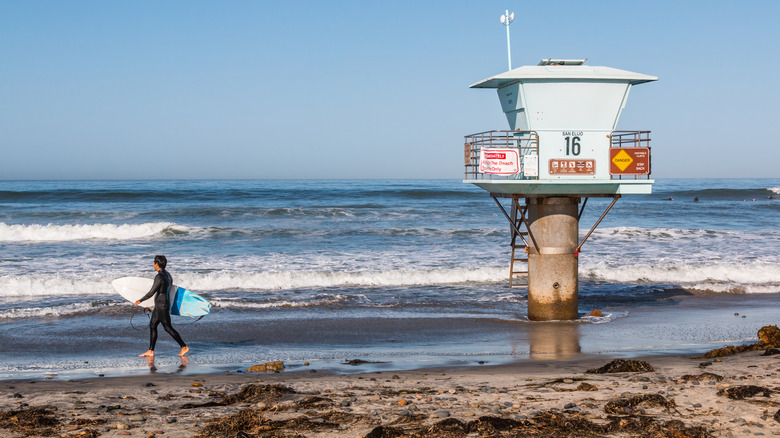 Surfer walking on the sand at on San Elijo State Beach