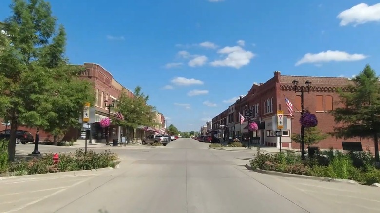 A downtown street with trees and brick buildings in Belle Plaine, Iowa