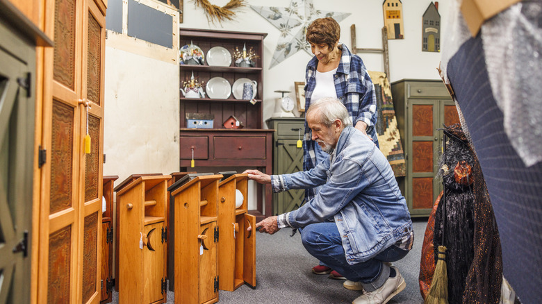 Senior couple browses for wood furniture in an Amish store.