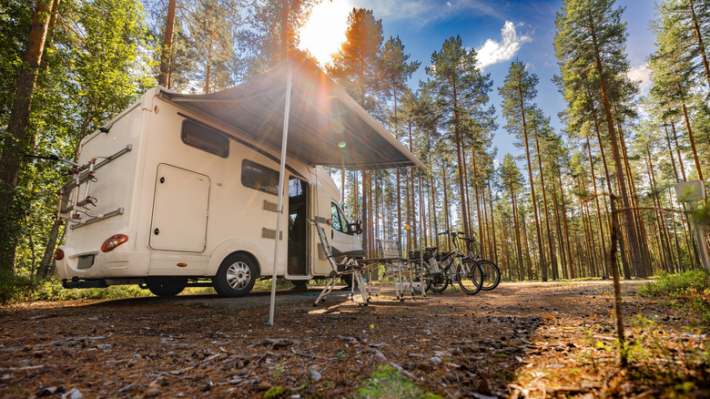 an RV parked in a wooded campsite