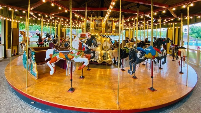 Carousel at Tuscora Park, with painted horses on a wooden platform under lights