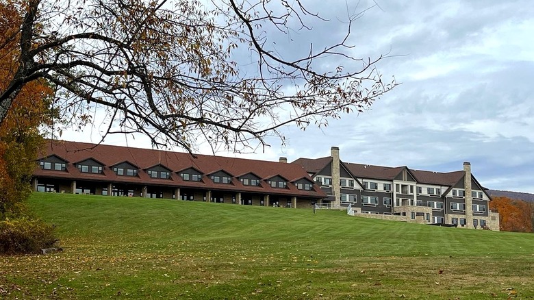 Lodge at Cacapon State Park under a cloudy sky with green grass in the foreground