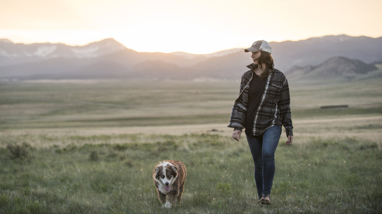 Woman hiking near mountains with dog