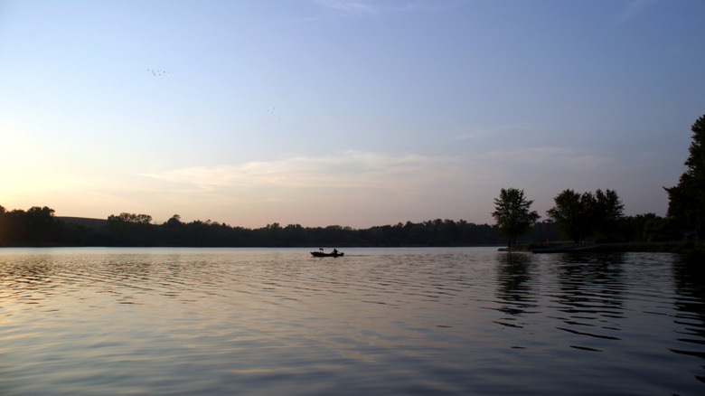 sunset views at the Rock Creek Lake in Iowa with a paddler in distance