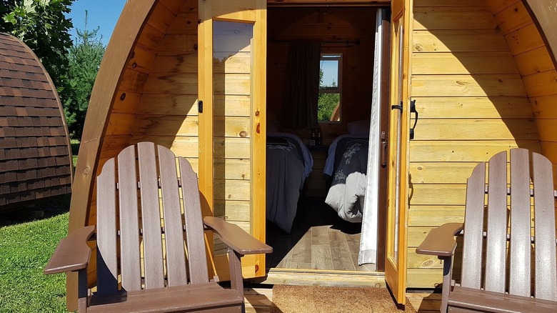 Glamping cabin with a porch and chairs at Long Point Eco-Adventures
