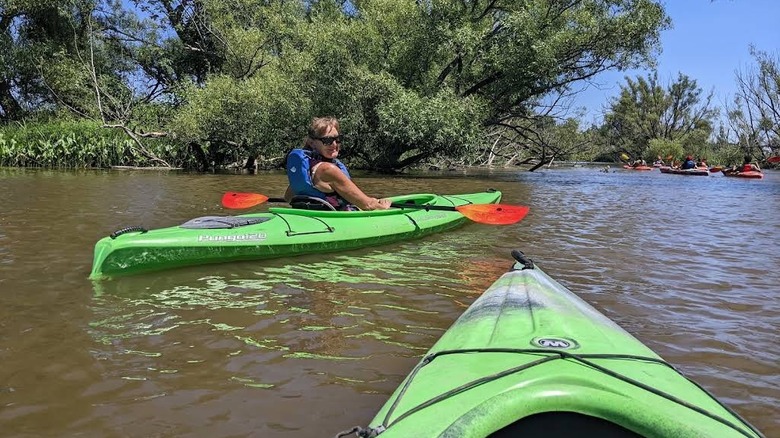 Woman in a green kayak on a river