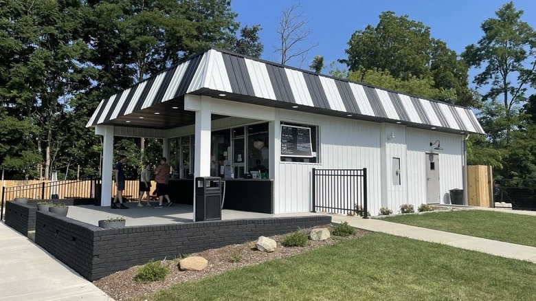 An ice cream stand with a black and white striped awning.