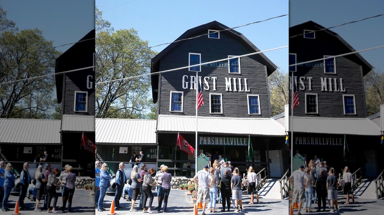 The historic three-story Tom Walker's Grist Mill, with black wood siding