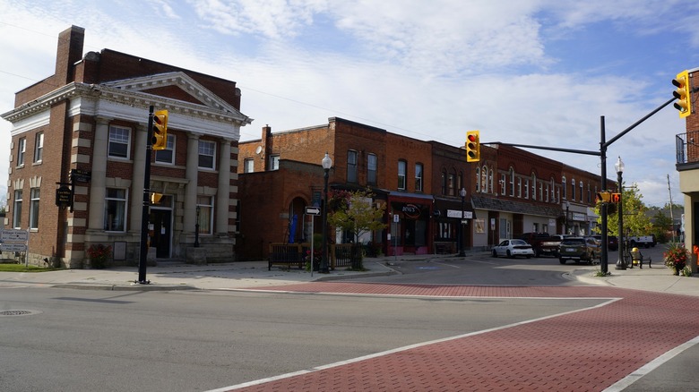 A quiet central intersection in downtown Cayuga, with two story brick buildings pressed against each other and crosswalks