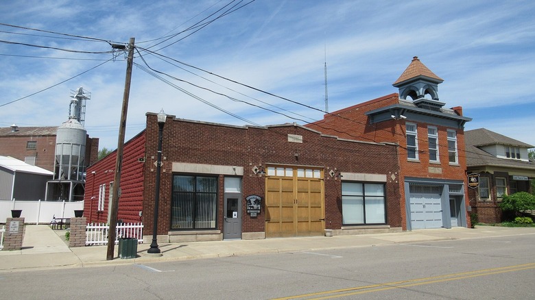 A downtown street and the brick village hall of Maybee, Michigan on a summer day