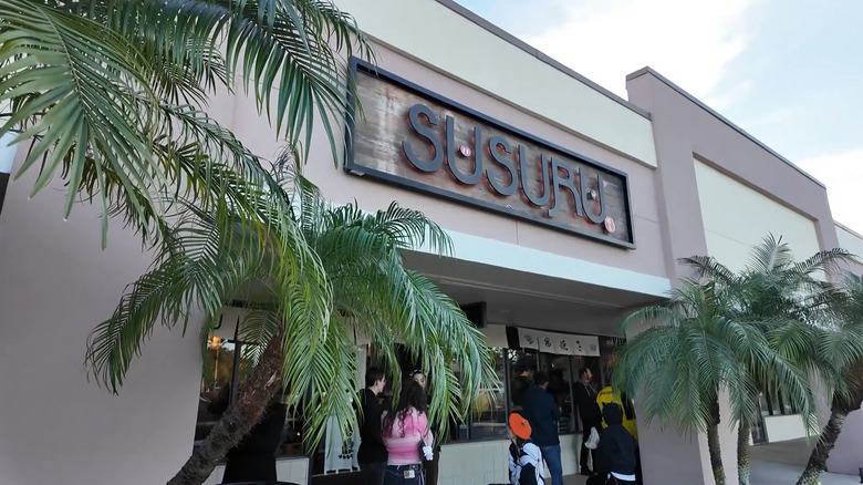 People wait in line outside the entrance of Susuru Japanese restaurant