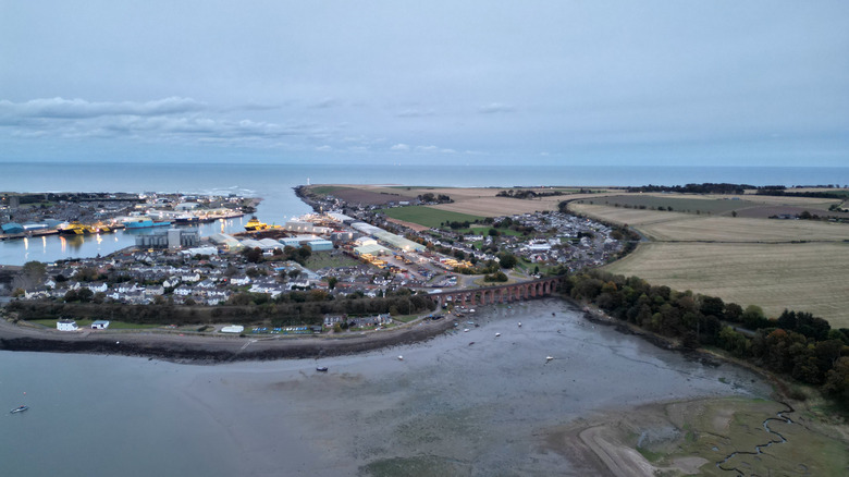 Shallow waters of river estuary by the harbor, dividing river from the sea.