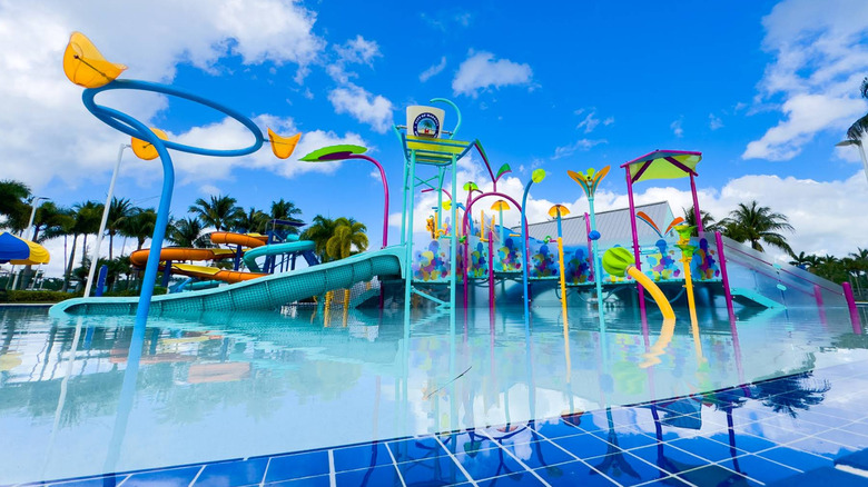 Calypso Cove Waterpark with slides and a play area and a pool in Margate, Florida, with a blue sky and palm trees