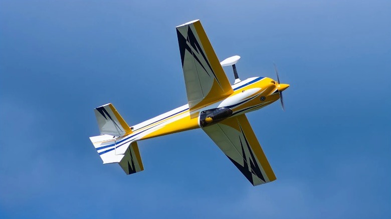 A yellow and blue RC plane performing a loop-de-loop in the sky above Walter RC Park.