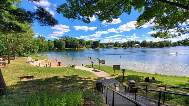 Grose Park Michigan's small beach area surrounded by trees and grass on Crockery Lake
