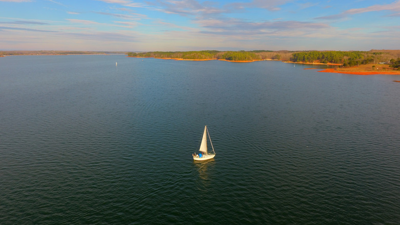 Aerial views of Lake Hartwell on the Georgia/South Carolina border, featuring a sailboat and a tree-lined shore.