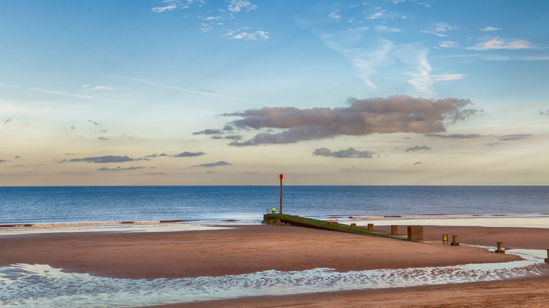 The Blue Flag-certified Mablethorpe Beach in Mablethorpe, England, with breakwater structure extending into the sea