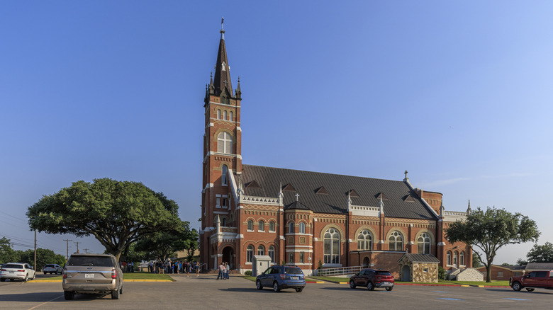 Saints Cyril and Methodius church in Shiner, Texas, with a large parking lot in front.