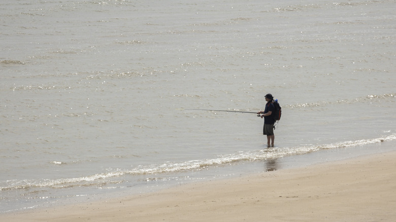 A lone individual fishing at the shore from the beach in Bridlington, England