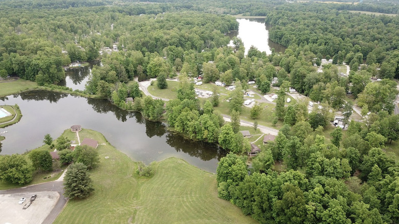 An aerial view of Indian Lakes RV Campground, depicting trees, lakes, campsites, and cabins.