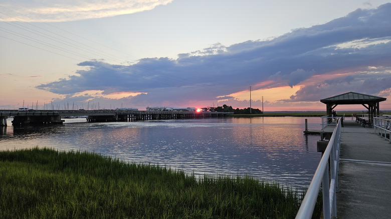 People fishing at the covered pavilion over the river during sunset at Gascoigne Bluff Park.