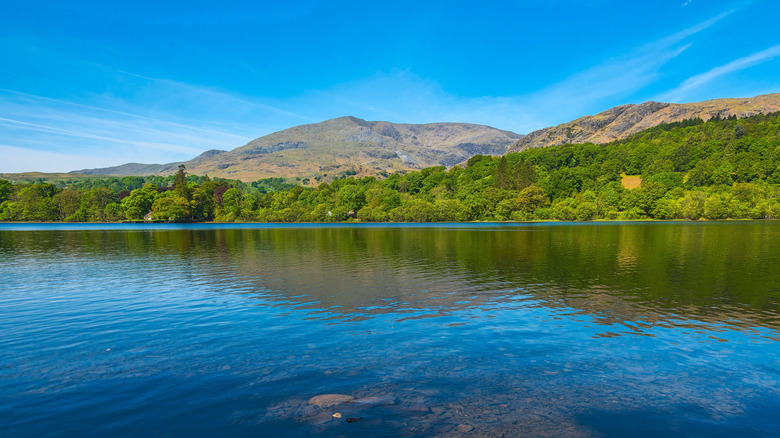 Coniston Water in the Lake District National Park, England, with blue waters and mountains in the background