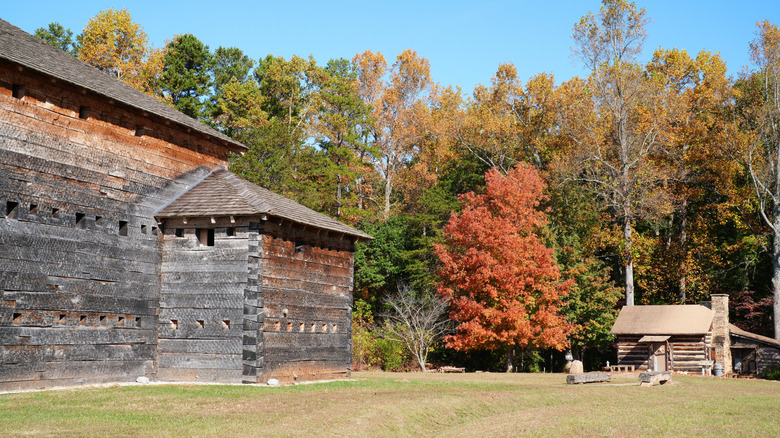 Old buildings as part of Fort Dobbs and surrounding trees with fall foliage